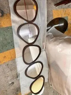 Organic-shape wall mirrors laid out for checking in a Jaipur factory