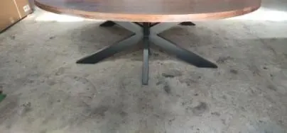 Oval dining table assembled on its cross-leg base for inspection