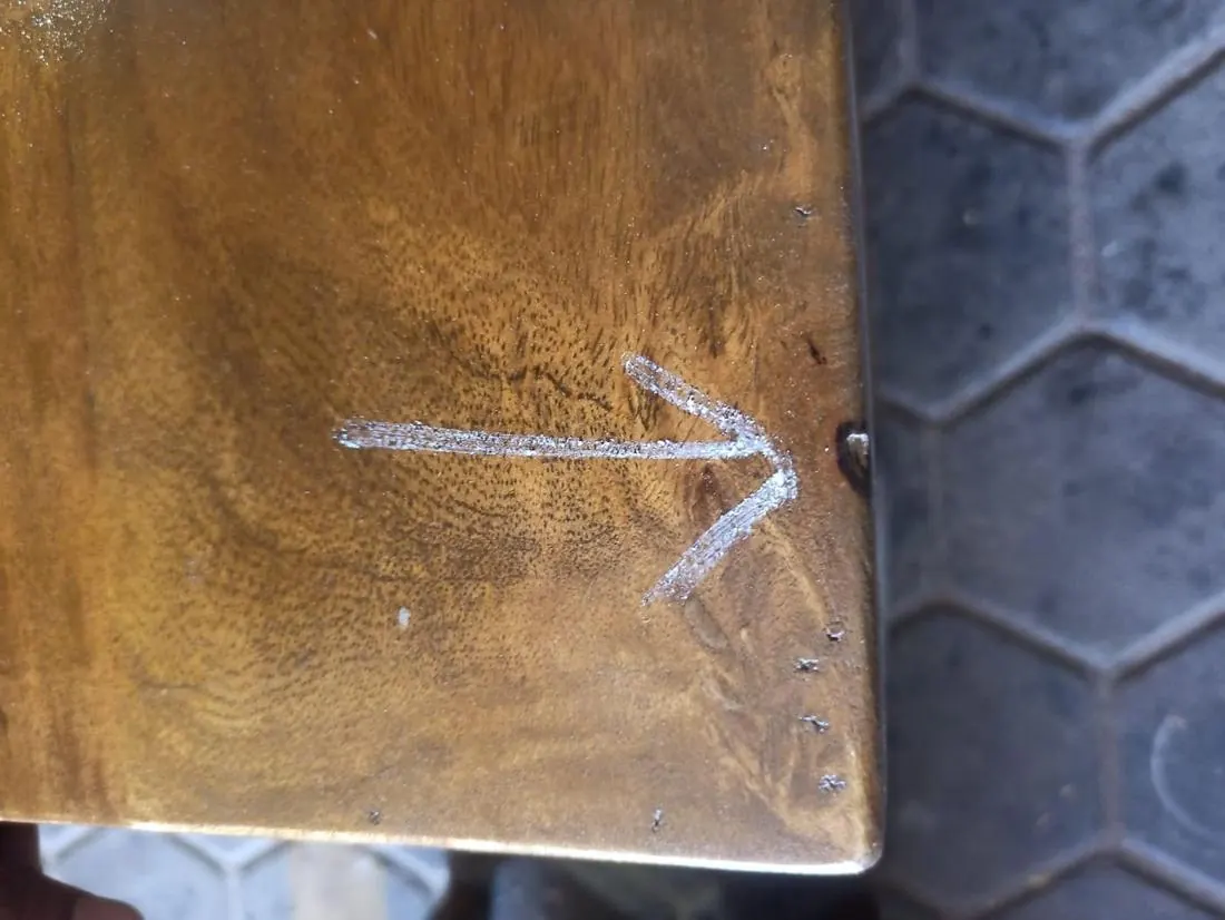 Major defect: poorly filled crack on a wooden TV unit, marked in chalk