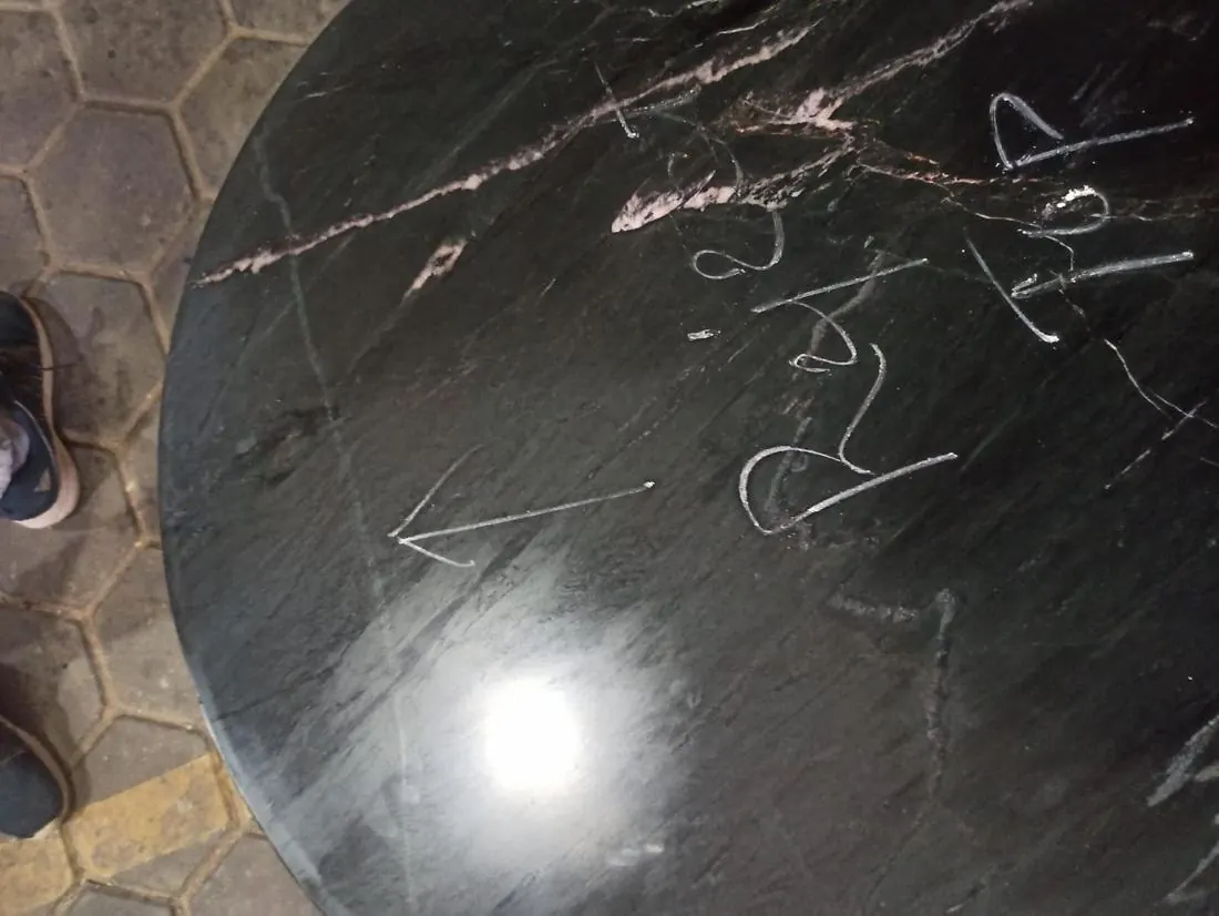 Major defect: crack in a black marble table top, marked in chalk