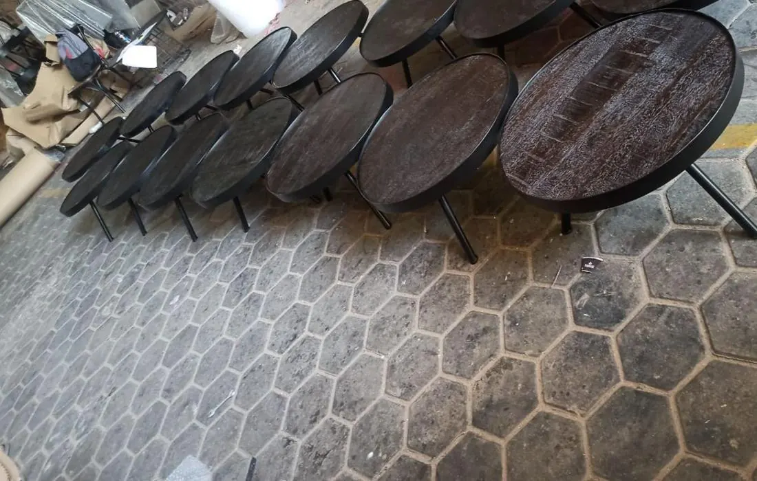 Round wood and iron tables lined up for inspection