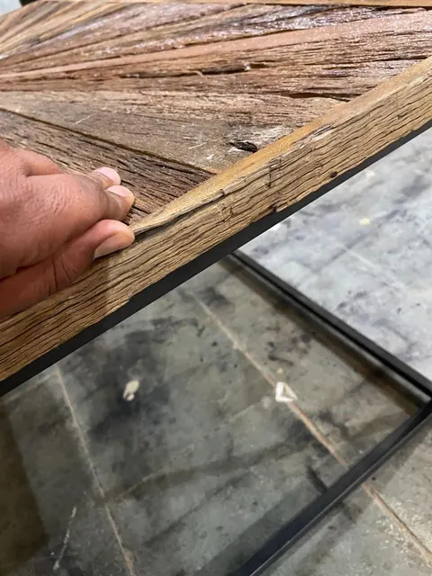 Minor defect: chipping on the wooden frame of a coffee table, fixed on site