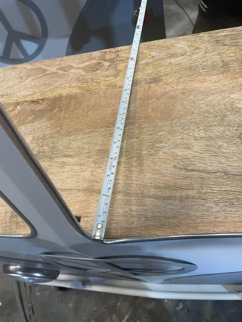 Measuring a cabinet's dimensions with a tape during inspection